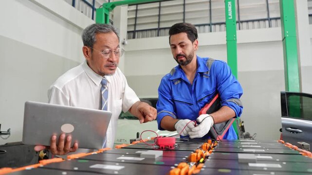 Team of engineers working together to test electrical equipment in a contemporary industrial setting