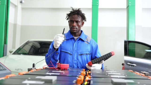 Expert technician repairing electric vehicle battery in a modern automotive workshop environment