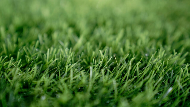 High-quality macro shot of lush green artificial grass or synthetic turf texture, vibrant color and realistic detail, perfect background for eco-friendly concepts, sports, garden, or spring season int