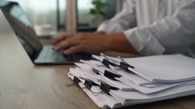 business man  sorting thick paper Document management system  on a wooden desk, showing an organized filing process for office records and document management workflow.