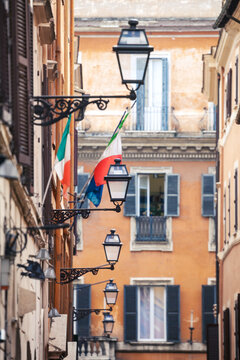 Ornate street lamp and Italian flags on a facade, Rome, Italy