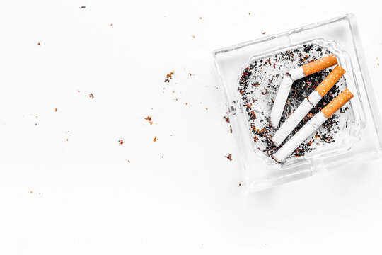 Smoking. Half-smoked cigarettes in ashtray on white background top view copy space