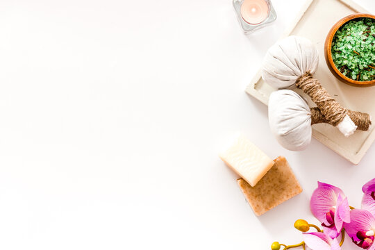 Preparing for massage in spa salon - with candles and orchids - white background top view frame copy space