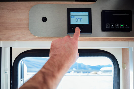 Hand of man switching off AC in camper van