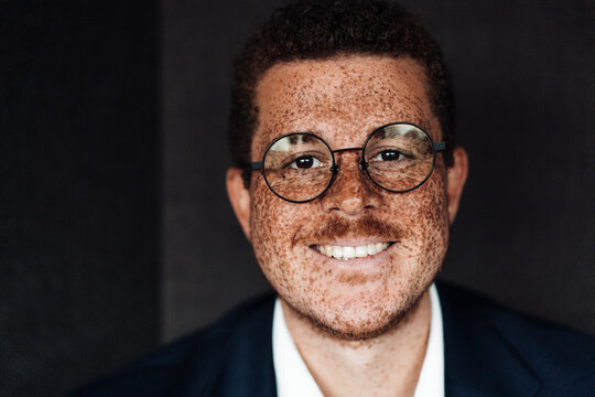 A smiling businessman with freckles loves his work at the office