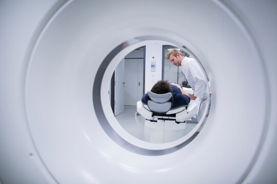Patient in hospital during CT examination and radiologist