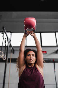 Sportswoman exercising with kettlebell at health club