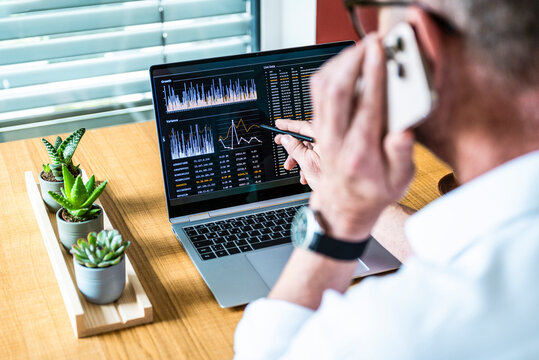 Broker analyzes finance data on notebook and talks on smartphone