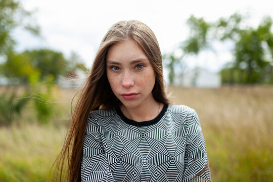Female model wears a patterned shirt in a summer field