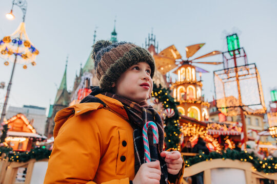 Boy holds candy at a winter Christmas market in Wroclaw