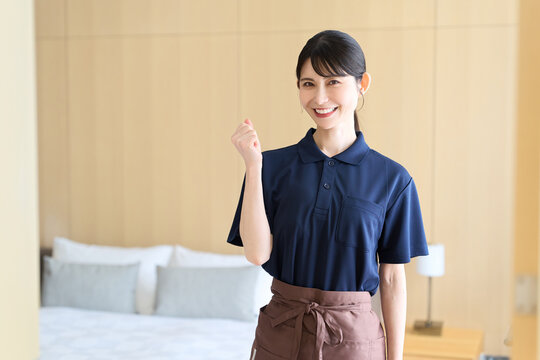 ガッツポーズをするホテルの女性清掃員