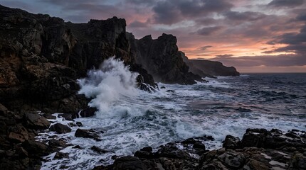 Fototapeta premium Powerful ocean waves crash against dark rocky cliffs at sunset under dramatic clouds, ideal for travel, nature, adventure, or coastal conservation promotions.