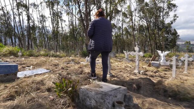 Women visiting their relatives grave in a rural cemetery remembering loved ones