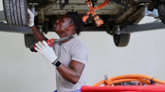 Mechanic conducting vehicle maintenance with a focus on replacing and inspecting tires for optimal performance