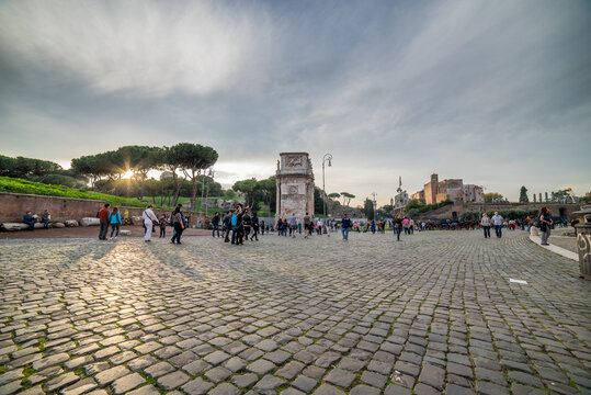 Sunset at Arch of Constantine with Tourists on Ancient Cobblestones, Roman Forum, Rome, Italy