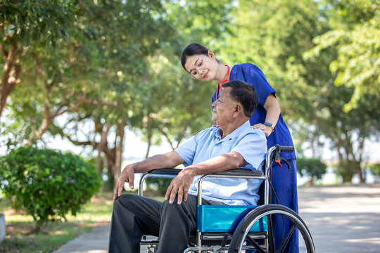 Female nurse caregiver male senior patient share a compassionate moment outdoors in park tranquil and supportive.