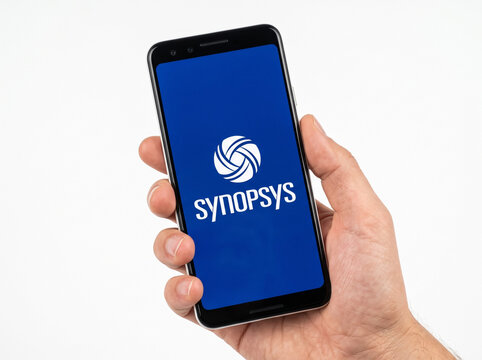 Synopsys logo is displayed on a modern smartphone screen, electronic design automation software, EDA tools, semiconductor IP, chip design solutions, mobile app interface held in hand, tech firm.