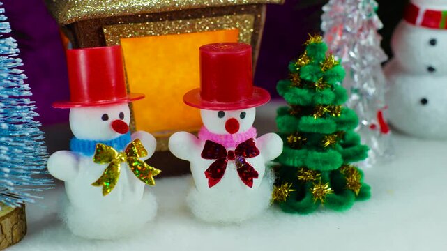Close-up of two snowmen in red hats near a Christmas lantern