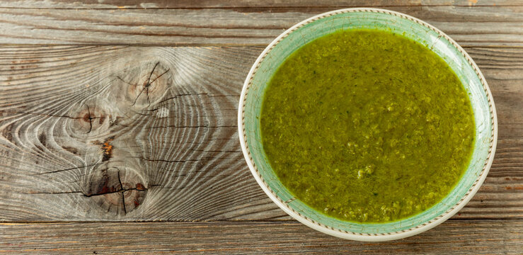 Soup of Romaine Lettuce with Mint. A classic French combination of braised lettuce leaves with a hint of mint. Rustic wooden background with space for additional concept.