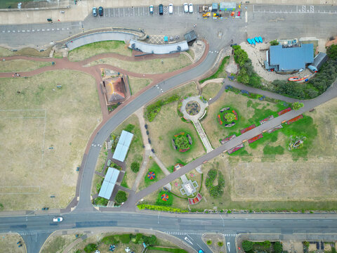 Interesting drone UAV view of parched grass seen during a summer drought in the coastal town of Hunstanton, Norfolk, UK. Showing part of the promenade, gardens and memorial.