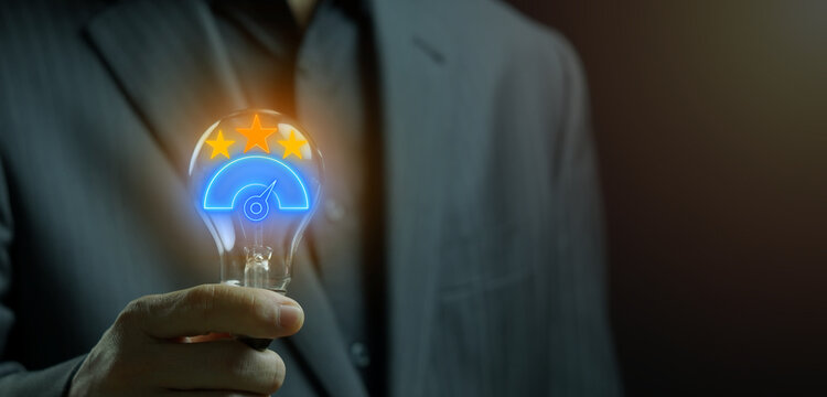 Hand holding lightbulb with glowing benchmarking icon. Business performance standard and strategic innovation concept.