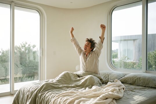 Person waking rested in bright serene bedroom stretching, sleep and recovery for longevity