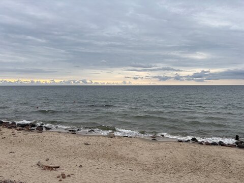 Serene beach landscape with gentle waves and cloudy sky at dusk  