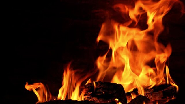 High-quality 4K video at 50fps showing roaring orange flames consuming firewood inside a rustic oven. High frame rate allows for smooth slow motion or real-time playback