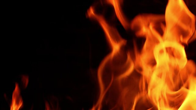 Premium 4K resolution footage shot at an extreme high frame rate of 100fps. Captures intense orange flames and glowing embers consuming wood logs in a dark rustic oven