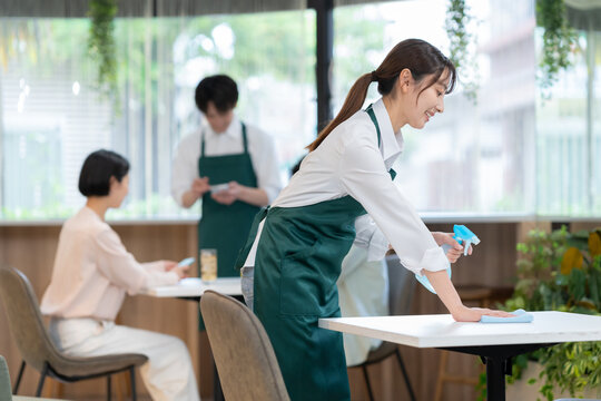 消毒をするカフェの若い女性店員