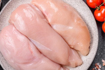 Fototapeta premium Fresh raw chicken fillet with salt and spices for home cooking. Raw chicken fillet