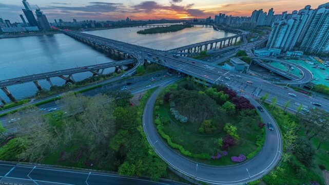 Stunning evening timelapse of Seoul metropolitan highway junction and infrastructure during golden sunset, beautiful city infrastructure and water reflection in South Korea.