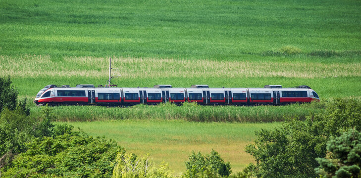 Neusiedl, Austria: OBB train on the railway among green scenery                                                                                                                                         