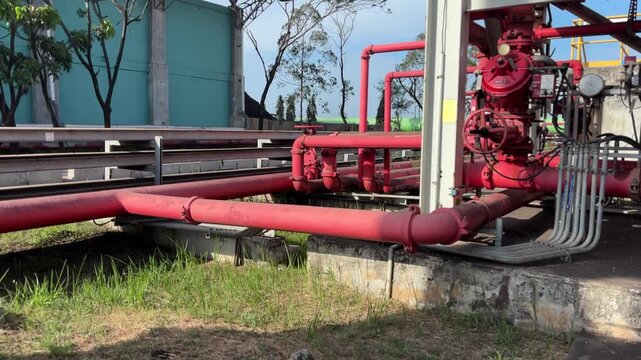 Red hydrant pipes run along concrete foundations