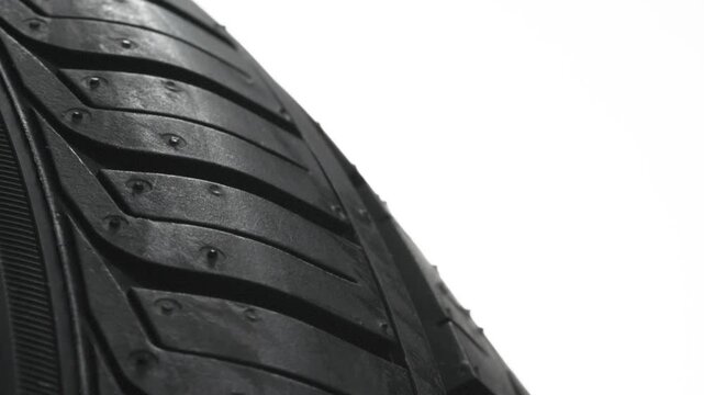 Wheel Tread in Circular Motion in White. Car wheel slowly rotates in front of the camera close-up on a white background