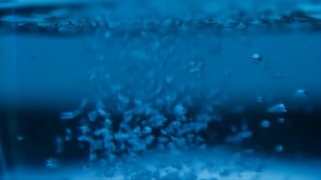 Boiling Water Bubbling with Blue Lighting in an Extreme Macro Shot Featuring Liquid, Steam, Vapor with Abstract and Dynamic Elements for Fluid