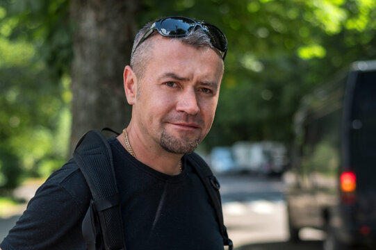 Portrait of Young Man Standing on City Street Looking at Camera