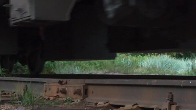 Locomotive Moving on Rails. Close-up of the rails and sleepers on which the wheel sets of a diesel locomotive and wagons pass