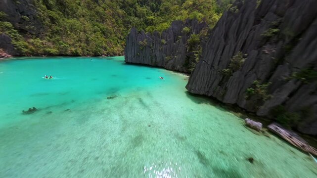 Cinematic FPV drone flight over dramatic limestone cliffs and turquoise water at Cadlao Lagoon, El Nido, Palawan, Philippines, revealing a hidden tropical paradise.