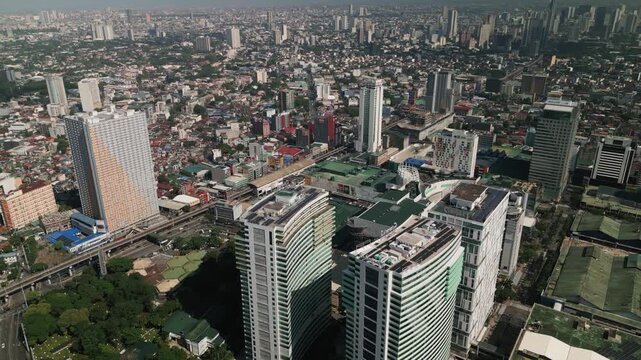 Panoramic aerial view of Quezon City, Metro Manila with corporate towers, dense residential blocks, and busy urban development in daylight