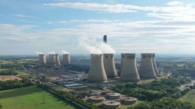 Power Station Cooling Towers Release Steam Into Blue Sky Over Green Fields