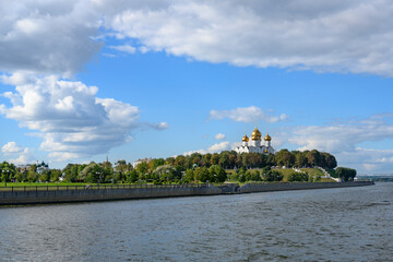 View of the Volga River embankment with the golden domes of the medieval Assumption Cathedral and white stairs descending to the river in Yaroslavl, Russia © Sergey