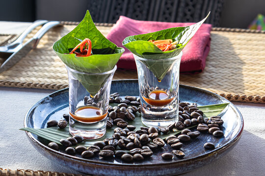 Creative Asian fusion appetizer Miang Kham served in shot glasses with roasted coffee beans.