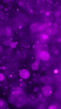 Abstract purple bokeh particles gently floating and shimmering in a dark background