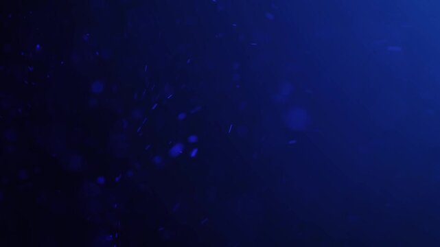 Abstract blue particles floating in dark water with subtle light effects
