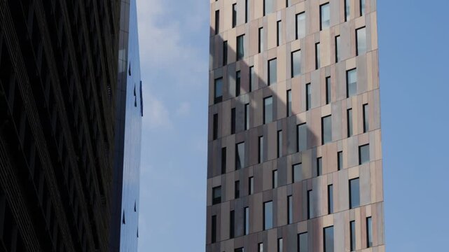 Modern glass office scyscraper buildings beautifully reflecting the clear blue sky in an urban environment