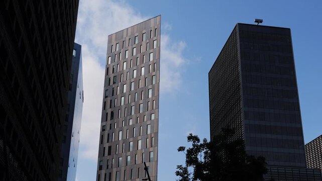 Modern glass office scyscraper buildings beautifully reflecting the clear blue sky in an urban environment