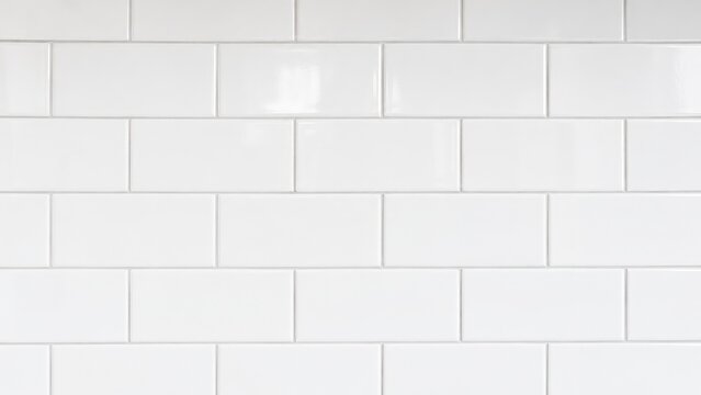 Glossy white subway tile wall with horizontal rectangular ceramic tiles and light gray grout, creating a clean modern kitchen or bathroom backsplash