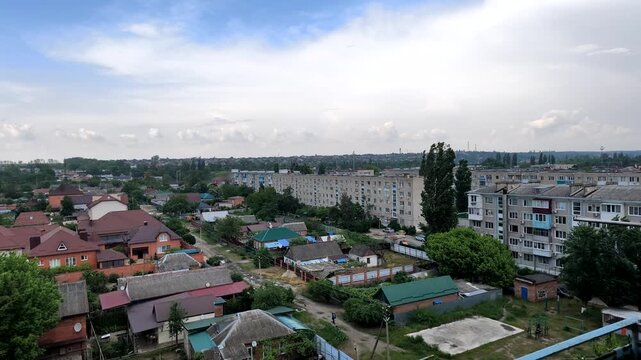 Aerial video of residential neighborhood with apartment buildings and houses under cloudy sky