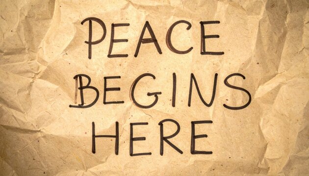 Peace Begins Here handwritten message on crumpled brown paper texture